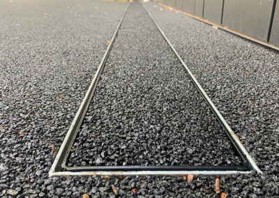 Close-up of permeable concrete surface with linear drainage system.