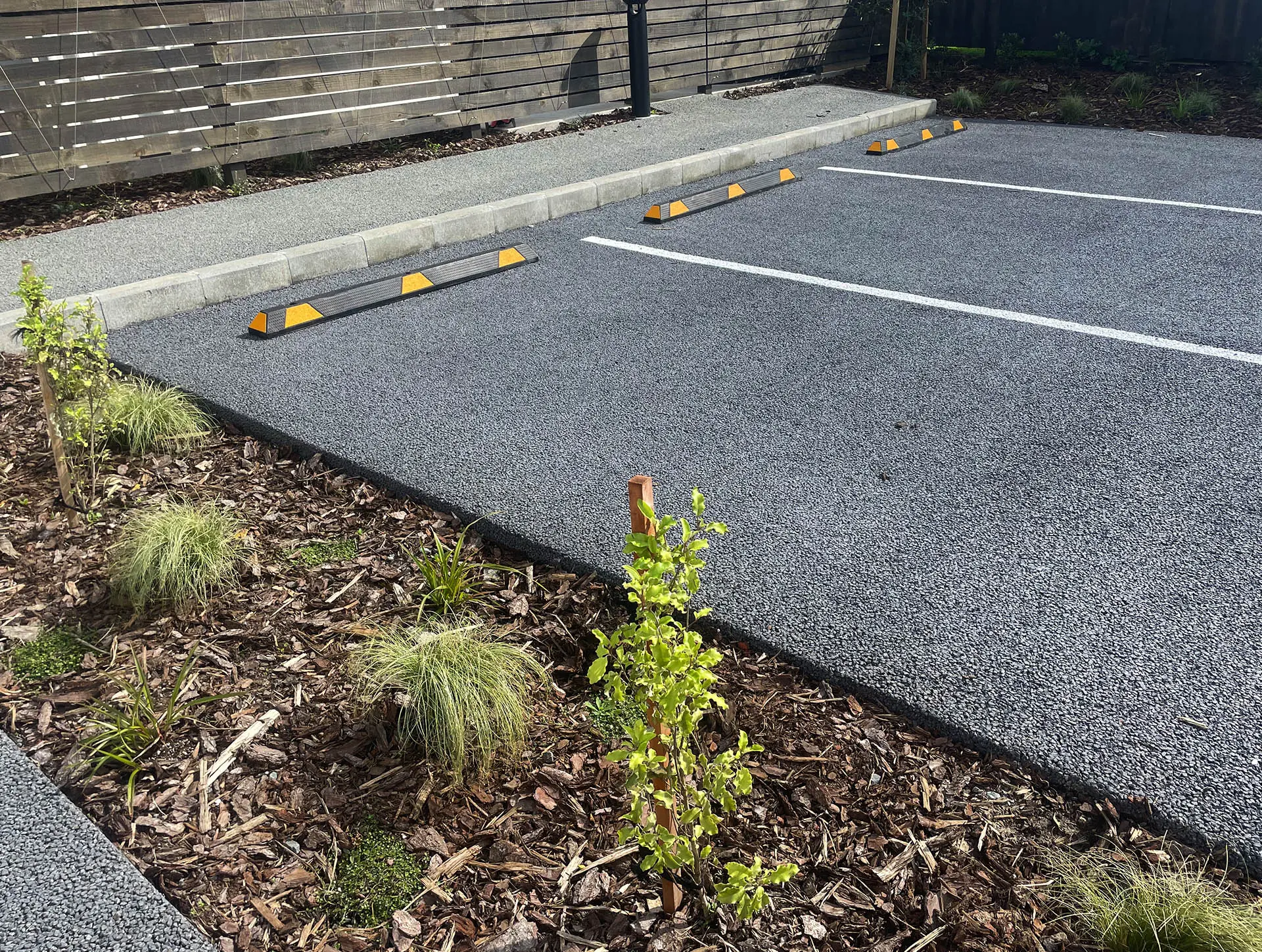 Permeable concrete driveway in front of modern residential buildings.
